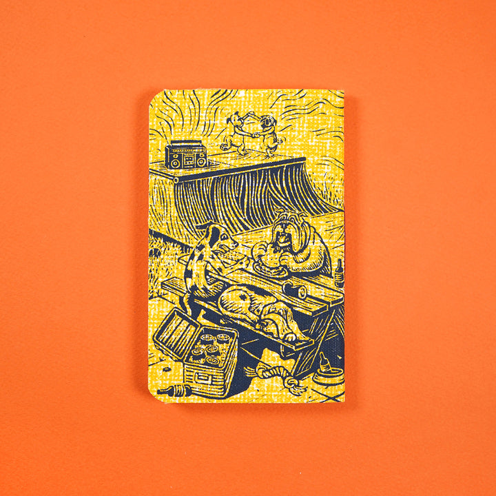 pocket notebook cover featuring two dogs dancing next to a stereo, two other dogs sitting on a picnic table eating, another dog sleep on the table&