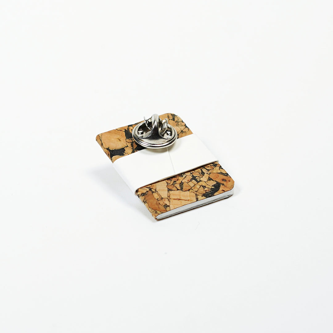 pin butterfly clasp on tiny notebook